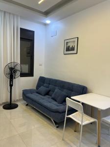 un salon avec un canapé bleu et une table dans l'établissement Nice place, à Irbid