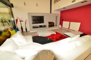ein Wohnzimmer mit einem weißen Sofa und einer roten Wand in der Unterkunft Futurcasa Casa rural Spa y cine in La Felipa