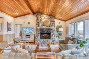 シーサイドにあるElk Ridge - Lux oceanfront family retreatのリビングルーム(大きな石造りの暖炉付) +101枚の写真