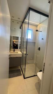 Apt luxo vista mar 160m com jacuzzi e 2 garagens في ايتابيما: حمام مع دش زجاجي ومرحاض +18 صورة