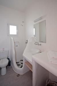 a white bathroom with a sink and a toilet at Marina's House in Tourlos