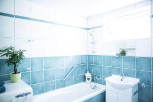 a bathroom with a white tub and a sink at Ferienhaus Sara - Kärnten Card im Sommer inklusive in Bad Kleinkirchheim