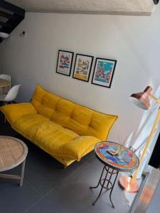 ein gelbes Sofa im Wohnzimmer mit einem Tisch in der Unterkunft HOM I Loft en mejor zona de Valparaiso 2PAX in Valparaíso