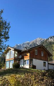a house on a hill with mountains in the background at Gipfelruhe Ramsau am Dachstein in Ramsau am Dachstein