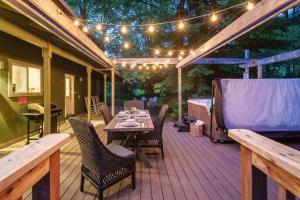 une terrasse en bois avec une table, des chaises et des lumières dans l'établissement Chateau Relaxeau Game Room Hot Tub Fire Pit, à Mount Hood Village