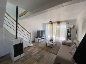 a living room with a couch and a flat screen tv at Charmante maison à louer in Lagor