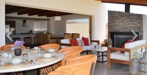 un salon avec une table et des chaises et une cuisine dans l'établissement Hermosa Cabaña en Exclusiva Zona en Valle de Lago, Tapalpa Jalisco, à Tapalpa