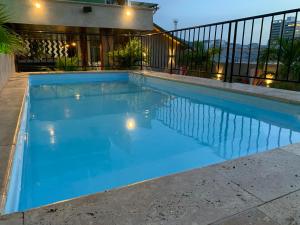 a swimming pool with blue water in front of a house at Hotel San Miguel Imperial in Santa Marta