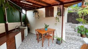 a patio with a wooden table and a sink at Cabana com banheira de Hidro e vista para o mar, privativa e tranquila localização excelente in Florianópolis +25 photos