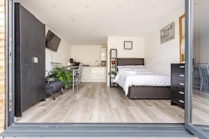 a large bedroom with a bed and a kitchen at Comfort Cabin Gravesend in Gravesend