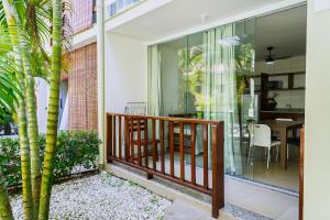 a balcony with glass doors and a table with a dining room at Para Vos y Porque Si in Morro de São Paulo