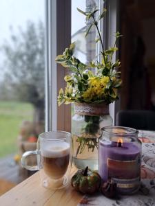 a table with a candle and a vase with flowers at Domeček Sára in Mohelnice +1 photo