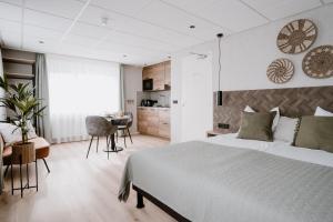 een slaapkamer met een groot bed en een bureau bij Hotel Kodde in Aagtekerke