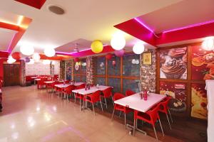 a restaurant with tables and red chairs and purple lighting at Hotel O Sher E Bengal in Durgāpur