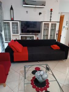 a living room with a black couch and a glass table at RnB Red&Black in Nafpaktos +58 photos