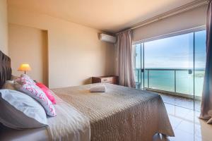 a bedroom with a bed with a view of the ocean at IPTZ170- Frente mar c/ vista incrível do 17º andar in Balneário Camboriú +66 photos