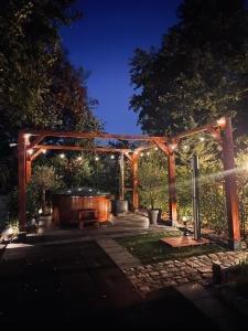 a wooden pergola with a hot tub in a yard at Kip en Hei in Schijf