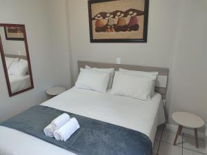 a bedroom with a bed with two towels on it at Aptos completos em Meia Praia a 150m do Mar - EOOs in Meia Praia