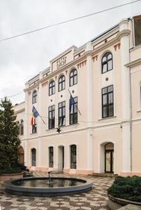 un gran edificio con banderas delante en Hotel Dacia, en Lugoj