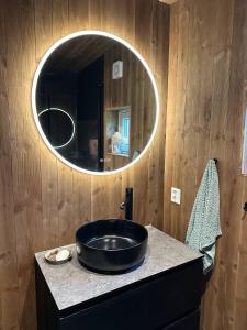 a bathroom with a black sink and a mirror at Architectural gem with fjord view in Holmedal +15 photos