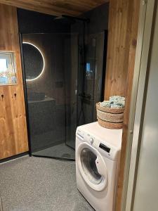 a washing machine in a bathroom with a shower at Architectural gem with fjord view in Holmedal +12 photos