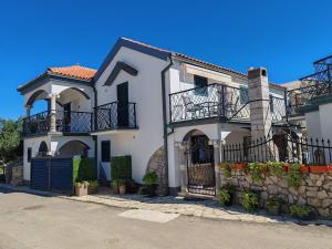 a white house with a gate and a fence at Apartments Liljana Privlaka in Privlaka