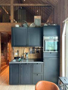 a kitchen with blue cabinets and a stove at Architectural gem with fjord view in Holmedal
