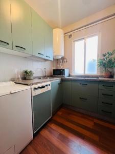 a kitchen with green and white cabinets and a window at Nueva Córdoba Judería in Córdoba
