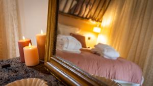ein Schlafzimmer mit einem Bett mit zwei Kerzen und einem Spiegel in der Unterkunft Au fil de l'O in Semur-en-Auxois
