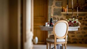 einen Tisch mit einem Stuhl und eine Flasche Wein in der Unterkunft Au fil de l'O in Semur-en-Auxois