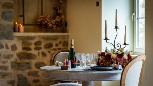 einen Tisch mit einer Flasche Wein und Gläsern in der Unterkunft Au fil de l'O in Semur-en-Auxois + 10 Fotos