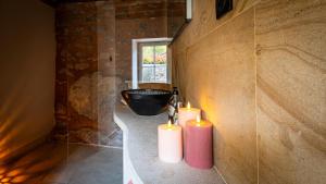 Zwei Kerzen in einem Badezimmer mit Badewanne in der Unterkunft Au fil de l'O in Semur-en-Auxois