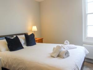 ダートマスにあるSimplesのタオルが敷かれた白いベッドのある寝室