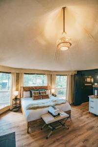 a bedroom with a large bed and a chandelier at Luxuring Glamping Tent - The Dog Wood - Near Tryon International Equestrian Center - Wheat Creek Outpost in Mill Spring