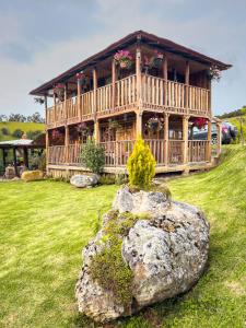 ein großes Holzhaus mit einem großen Felsen davor in der Unterkunft Hotel - Posada Las Rocas - Guasca Cundinamarca in El Lindero + 24 Fotos