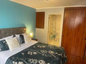 Un dormitorio con una cama grande y un baño. en Foresta Urban Suites, en Santiago