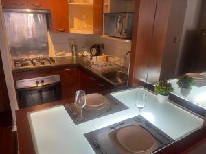 una cocina con 2 copas de vino en una barra en Foresta Urban Suites, en Santiago 6 fotos más