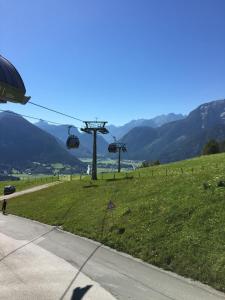 a gondola lift in a field of grass with mountains at Haus Fernsebner in Lofer