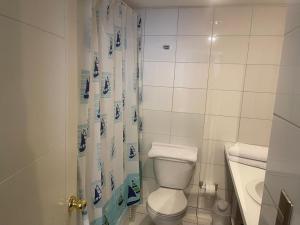 Un baño con inodoro, ducha y lavabo. en Foresta Urban Suites, en Santiago