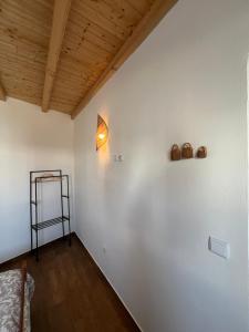 a room with a white wall with a lamp and a shelf at Casa do Mestre in Amieira