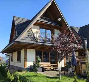 a house with a bench in front of it at Holne domki in Poronin
