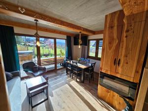 a living room with a fireplace and a dining room at Holne domki in Poronin