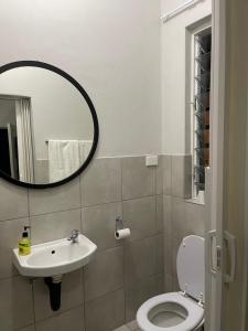 a bathroom with a sink and a toilet and a mirror at Lani Accommodation in Pretoria +4 photos