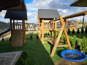 a wooden playground with a slide and a slideintend at Holne domki in Poronin