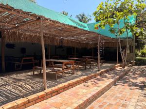 a patio with wooden tables and a green roof at Viva O Sonho 