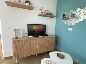 a living room with a tv on a wooden cabinet at Wake up to the Oceanfront Panoramic 180º Beachview Torrox-Costa Ruselo R408 ONLY ADULTS in Torrox Costa +43 photos
