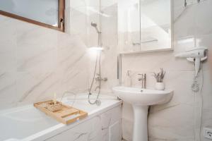 a white bathroom with a sink and a shower at Airport Connection in Iaşi