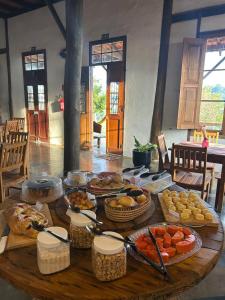 a wooden table with a bunch of food on it at Pousada Mãe Terra in Torrinha
