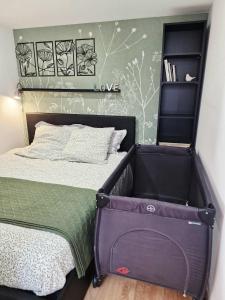 - une petite chambre avec un lit et une valise dans l'établissement Gîte Studio 4 à 6 personnes, à Doué-la-Fontaine