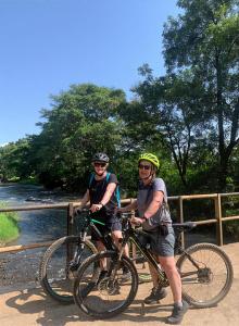 two men are standing with their bikes on a bridge at Materuni Home Stay in Uru East